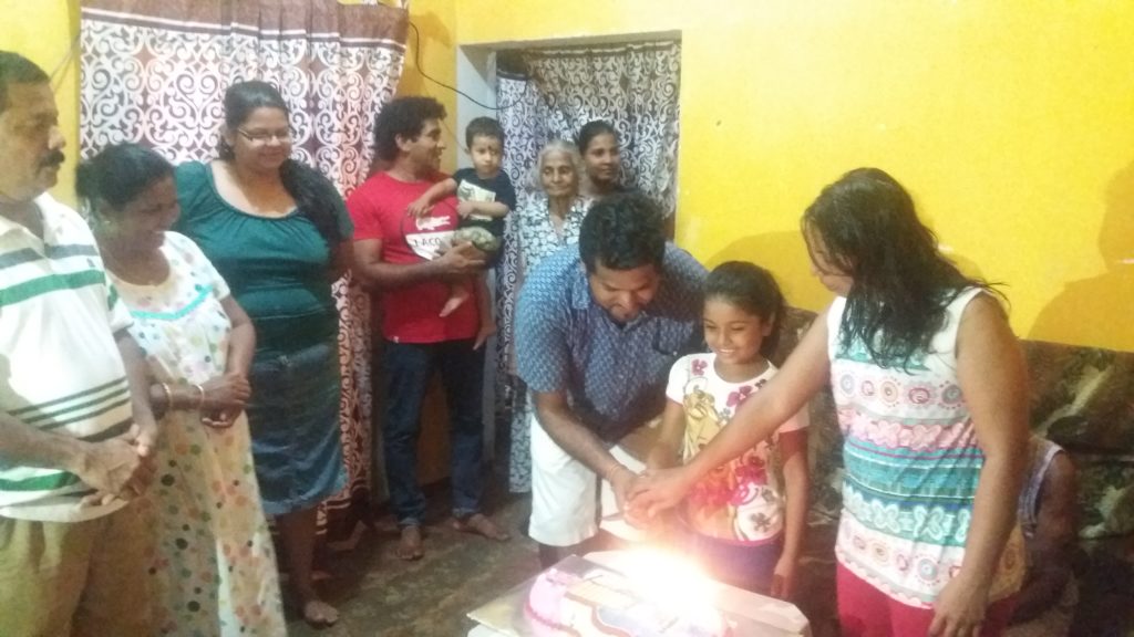 Oslava narozenin ve srílanské rodině. Zvykem je, že oslavenec vezme přímo do ruky první ukrojený kousek dortu a každý host si z něj musí ukousnout. I třeba 15 lidí kouše do jednoho kousku dortu, musí zbýt i na toho posledního.