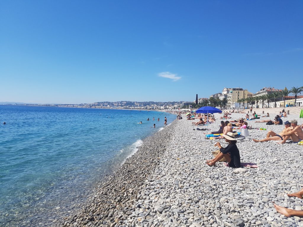 Hlavní pláž v Nice s průzračným mořem.