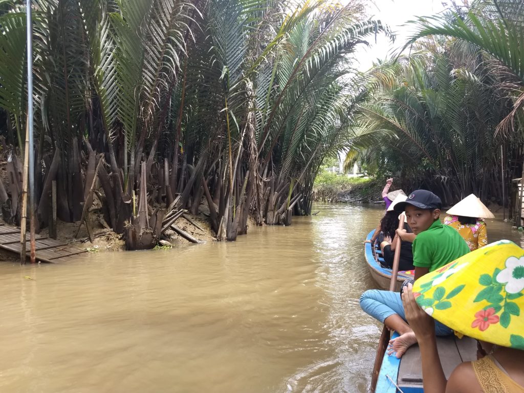 Jízda na tradiční loďce v jednom z postranních kanálů delty Mekongu.