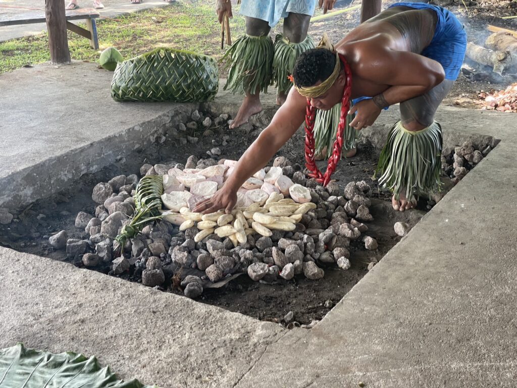 Příprava jídla tradičním způsobem v zemní peci během kulturní show, Samoa.